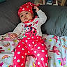 Dahlia is registered to the contest to win money with this photo: baby, infant, polka_dot, red_clothing, hat, blanket, unicorn, rainbow, pillow, bed, indoors, cute, child, person, sitting, colorful, cozy, furniture, sleepsuit, playful