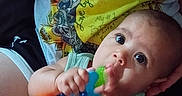 Dahlia is registered to the contest to win money with this photo: baby, infant, toy, teething_toy, person, hand, clothing, colorful, sunflower, pattern, portrait, cute, child, skin, face, eyes, sitting, holding, comfort, casual