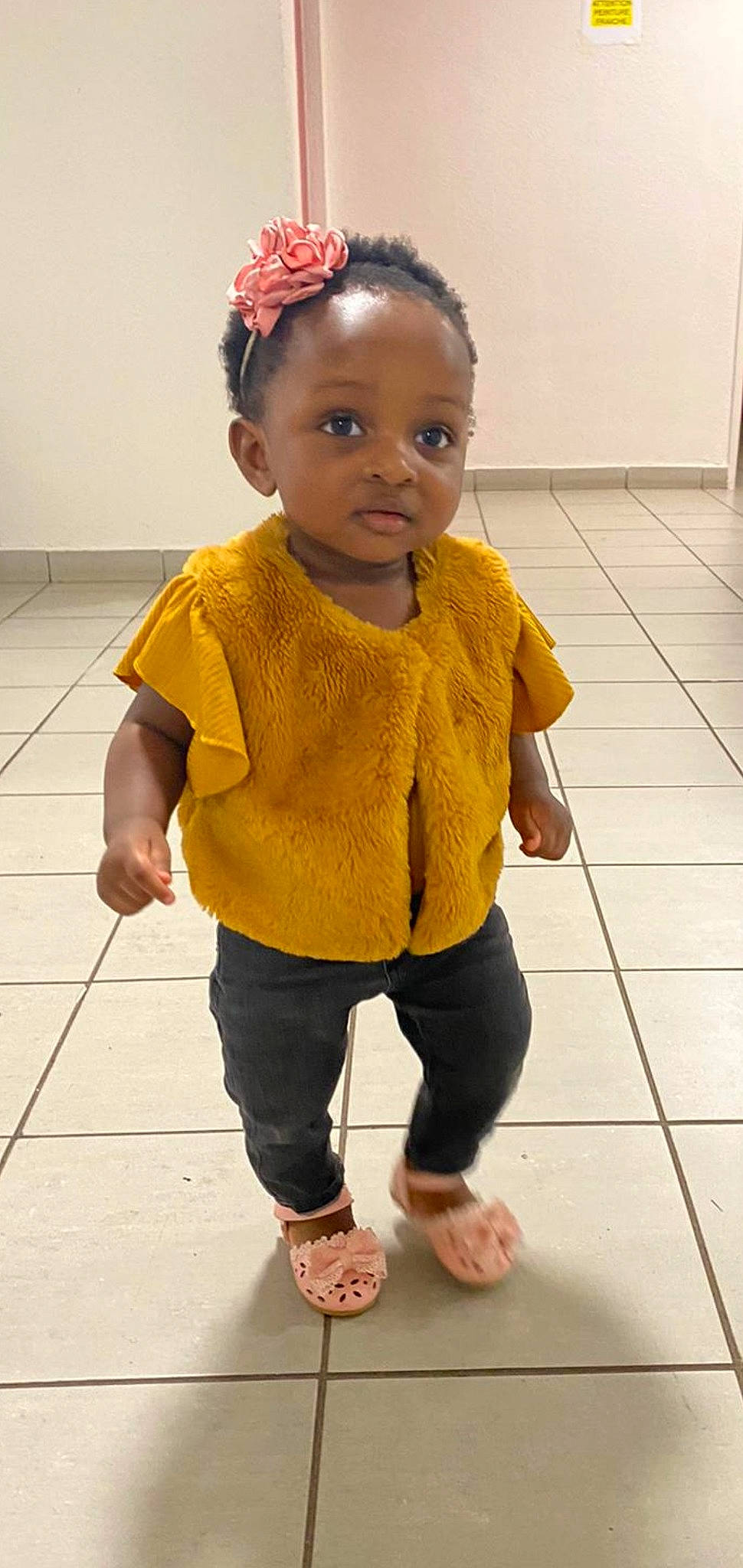 Eliana participe au concours pour gagner de l'argent avec cette photo : arm, baby_toddler_clothing, chin, face, flooring, hair, hairstyle, hand, head, human_body, joint, leg, neck, nose, person, photograph, skin, sleeve, standing, toddler