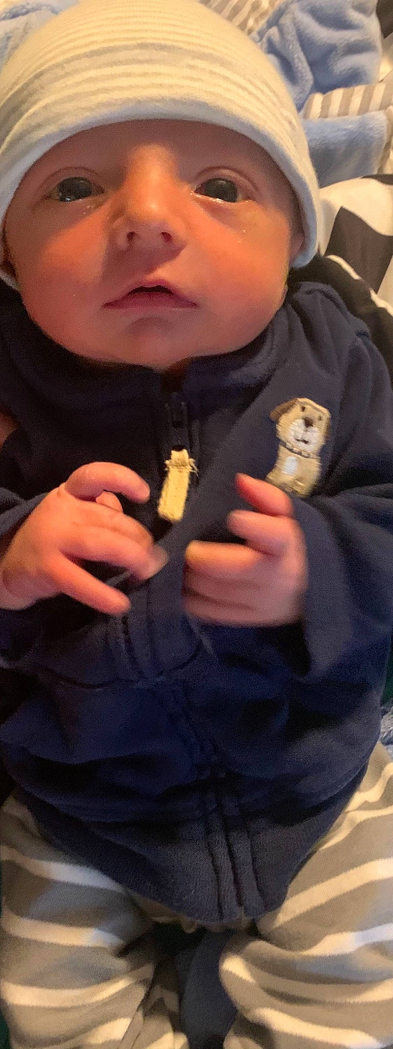 Owen is registered to the contest to win money with this photo: baby, baby_toddler_clothing, cheek, cool, finger, gesture, hand, headwear, hoodie, human, nail, person, skin, thumb