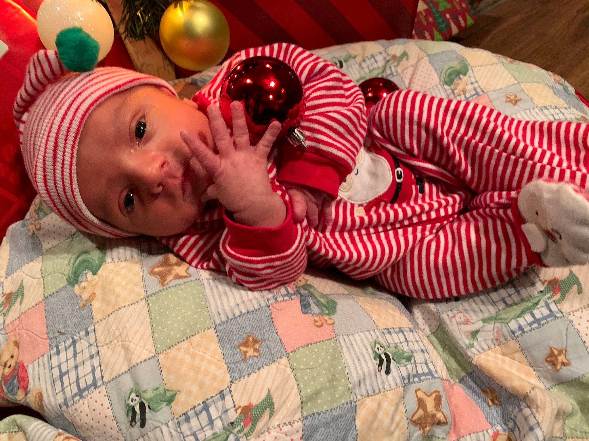 Owen is registered to the contest to win money with this photo: baby, baby_products, baby_toddler_clothing, beanie, blanket, child, christmas, comfort, headwear, holiday, home_accessories, human, human_body, linens, living_room, nightwear, nose, person, quilt, sock