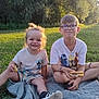 Loé a rejoint le concours — aidez-le/la à gagner de superbes lots ! child, children, picnic, blanket, grass, outdoor, sunlight, smile, food, sandwich, happy, glasses, nature, trees, casual_clothing, sitting, daylight, park, footwear, playful