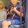 Elio participe au concours pour gagner de l'argent avec cette photo : child, boy, glasses, shorts, sitting, gear, vehicle_interior, cabin, equipment, smile, curly_hair, standing, casual_clothing, yellow_shoes, hose, seat, person, indoor, adventure, friends