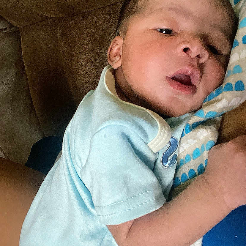 Kaison joined the competition — help win amazing prizes! baby, infant, onesie, blanket, couch, indoor, child, newborn, face, skin, person, comfort, resting, cute, toddler, young, portrait, soft, warm, cozy