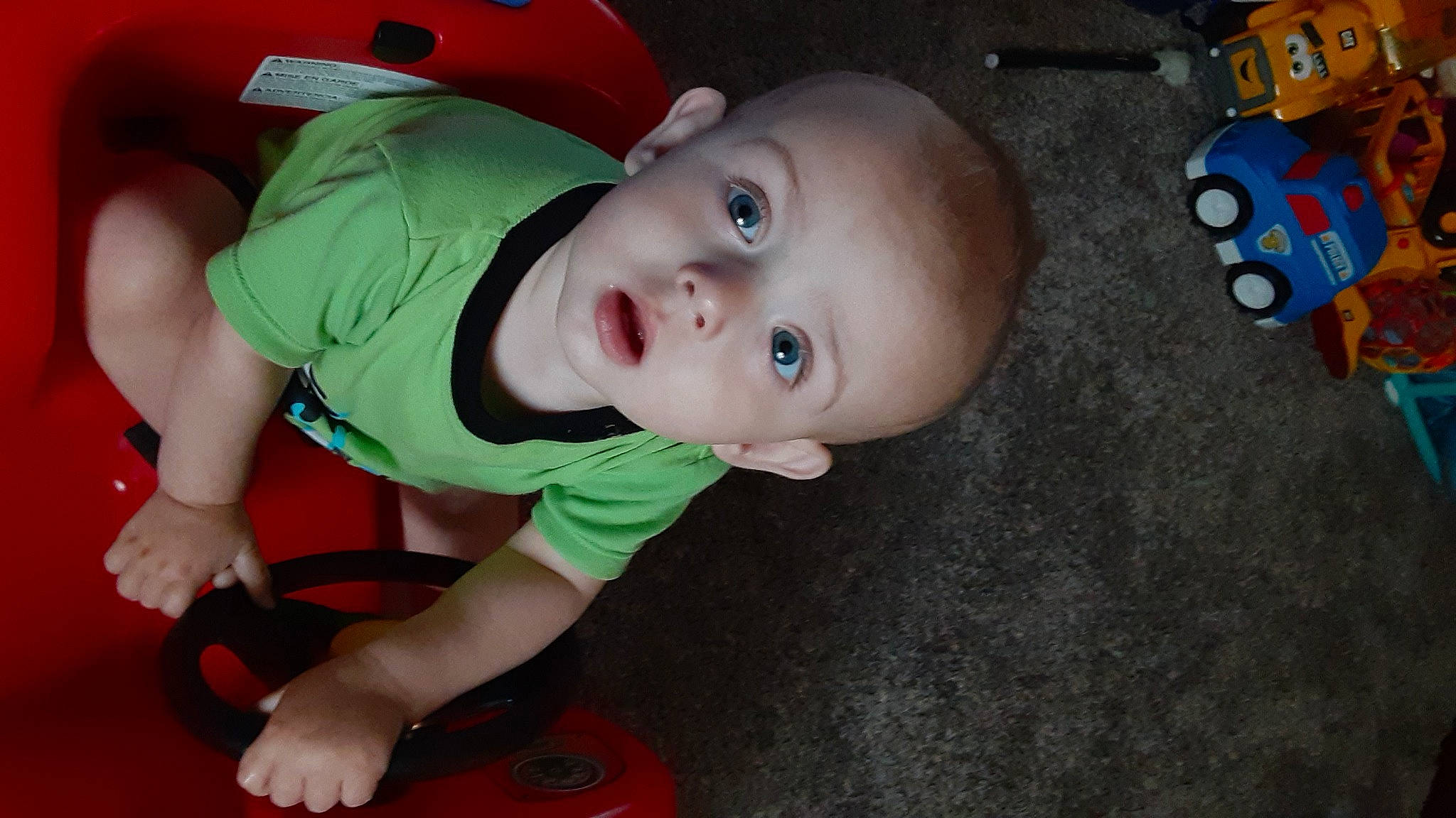 Roger is registered to the contest to win money with this photo: baby, baby_products, baby_toddler_clothing, carmine, cheek, child, flooring, fun, grass, happy, mouth, nose, person, play, room, sitting, skin, smile, toddler, toy