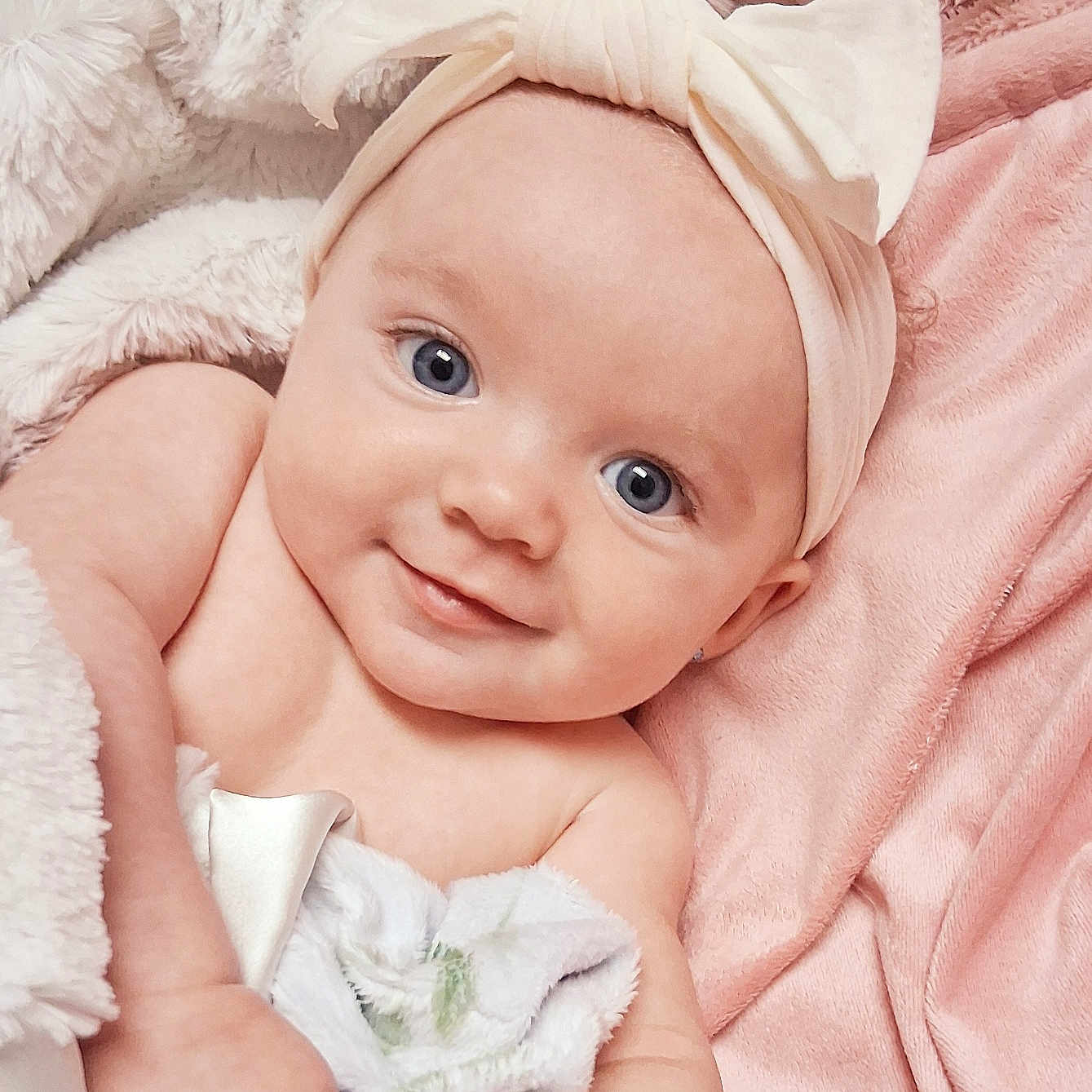 Klover is registered to the contest to win money with this photo: baby, blanket, blue_eyes, bow, child, comfort, cozy, cute, happy, headband, indoors, infant, pink_background, portrait, skin, smile, soft_texture, warm, wrapped, young