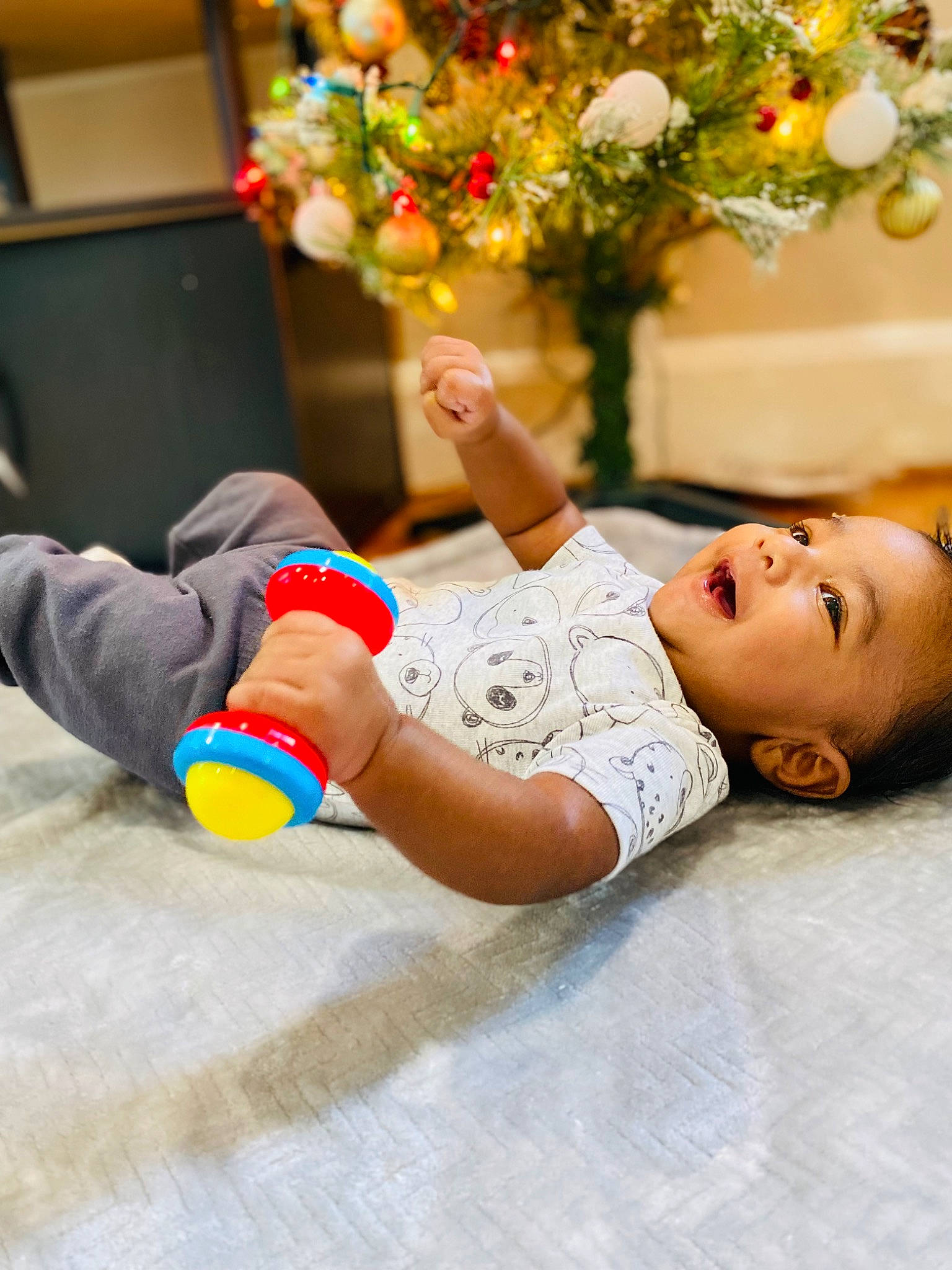 Chris is registered to the contest to win money with this photo: arm, child, event, floor, flooring, flower, flower_arranging, foot, fun, gesture, happy, human_leg, leisure, orange, person, plant, rose, sitting, smile, thigh