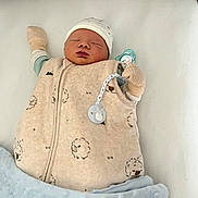 élian participe au concours pour gagner de l'argent avec cette photo : newborn, baby, sleeping, infant, blanket, mittens, hat, sleeping_bag, cozy, cute, soft, indoors, child, resting, peaceful, white_background, blue_blanket, closeup, face, pacifier