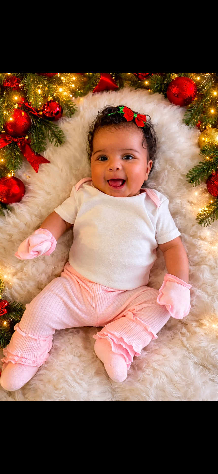 Serenity joined the competition — help win amazing prizes! baby, infant, smiling, christmas, holiday, decorations, ornaments, lights, white_rug, pink_clothing, mittens, happy, cute, festive, headband, indoor, portrait, celebration, child, seasonal