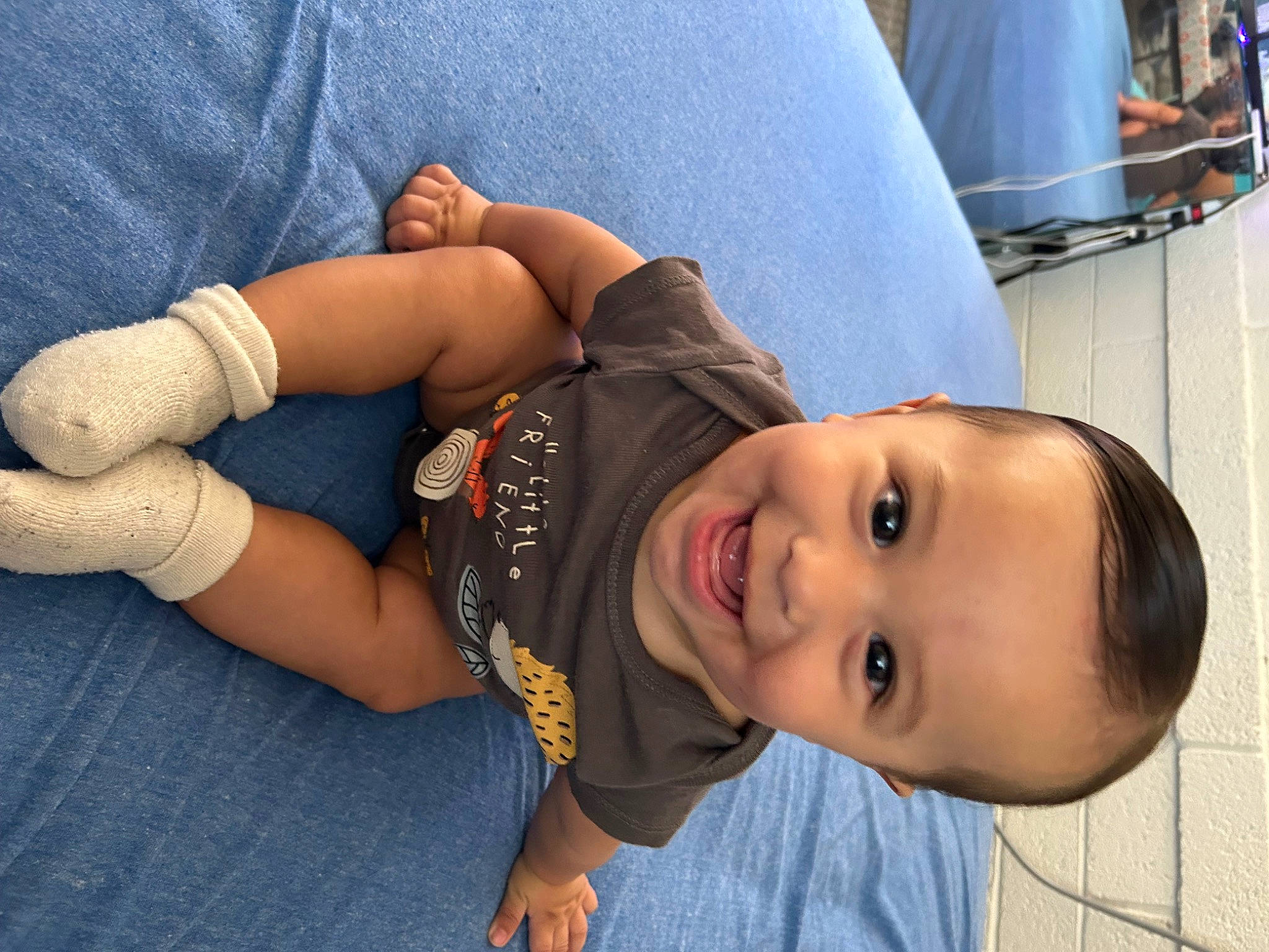 Fernando is registered to the contest to win money with this photo: baby, child, comfort, denim, elbow, fun, grass, happy, hat, human_leg, joy, knee, leisure, mouth, person, sitting, skin, sleeve, smile, thigh