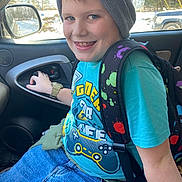 Kaisen is registered to the contest to win money with this photo: child, boy, smiling, beanie, backpack, car_interior, seat, door_handle, window, snow, vehicle, blue_clothing, jeans, watch, happy, portrait, casual, indoor, playful, person