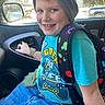 child, boy, smiling, beanie, backpack, car_interior, seat, door_handle, window, snow, vehicle, blue_clothing, jeans, watch, happy, portrait, casual, indoor, playful, person