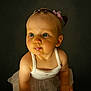 baby, child, blue_eyes, pink_hair_ties, white_tank_top, tutu, cute, curious, pout, sitting, barefoot, infant, portrait, studio_lighting, dark_background, adorable, chubby_cheeks, young_child, close_up, innocent