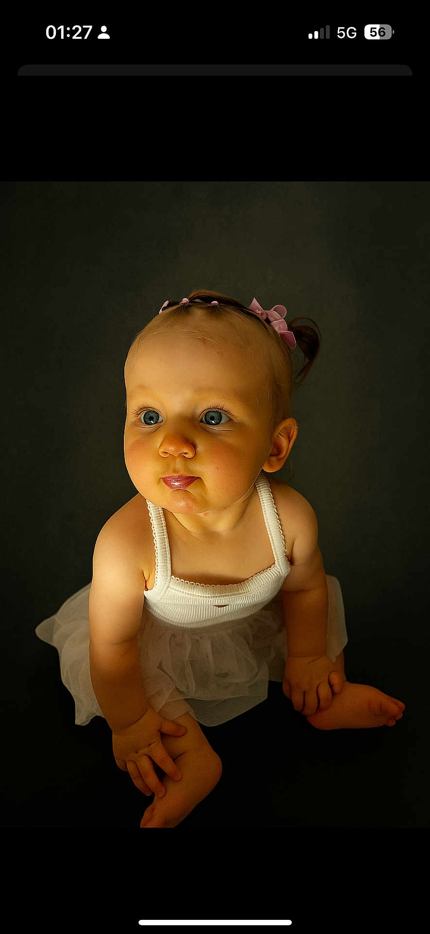 Lovana participe au concours pour gagner de l'argent avec cette photo : baby, child, blue_eyes, pink_hair_ties, white_tank_top, tutu, cute, curious, pout, sitting, barefoot, infant, portrait, studio_lighting, dark_background, adorable, chubby_cheeks, young_child, close_up, innocent