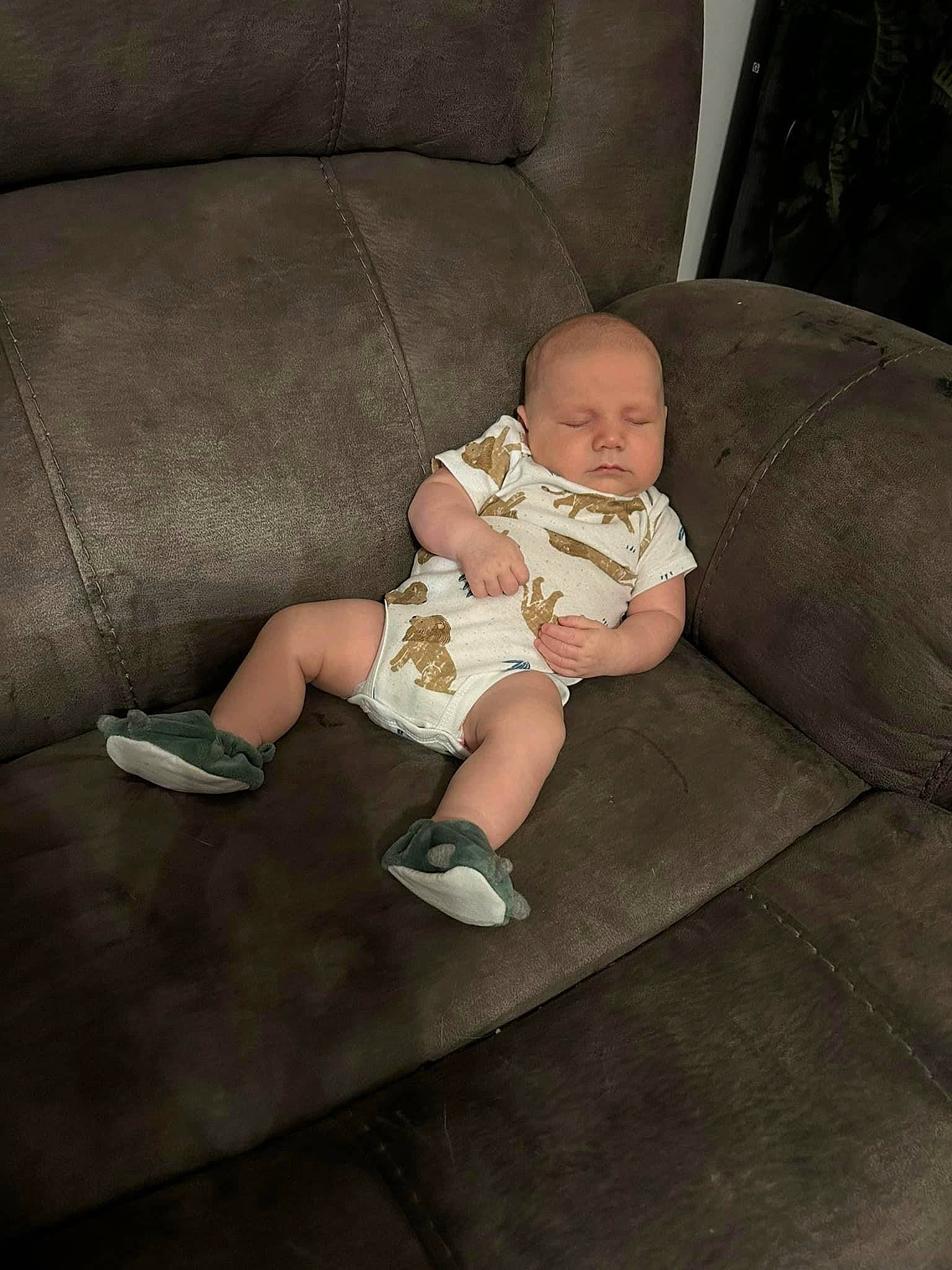 Knox is registered to the contest to win money with this photo: baby, baby_toddler_clothing, child, comfort, couch, flooring, foot, grass, human_leg, knee, lap, leg, person, room, sandal, shorts, sitting, sock, thigh, toddler