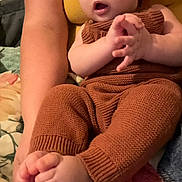 Harrison is registered to the contest to win money with this photo: baby, blanket, bodypart, clothing, couch, cushion, face, finger, furniture, hand, head, homedecor, indoors, knitwear, pants, person, photography, portrait, sitting, sweater