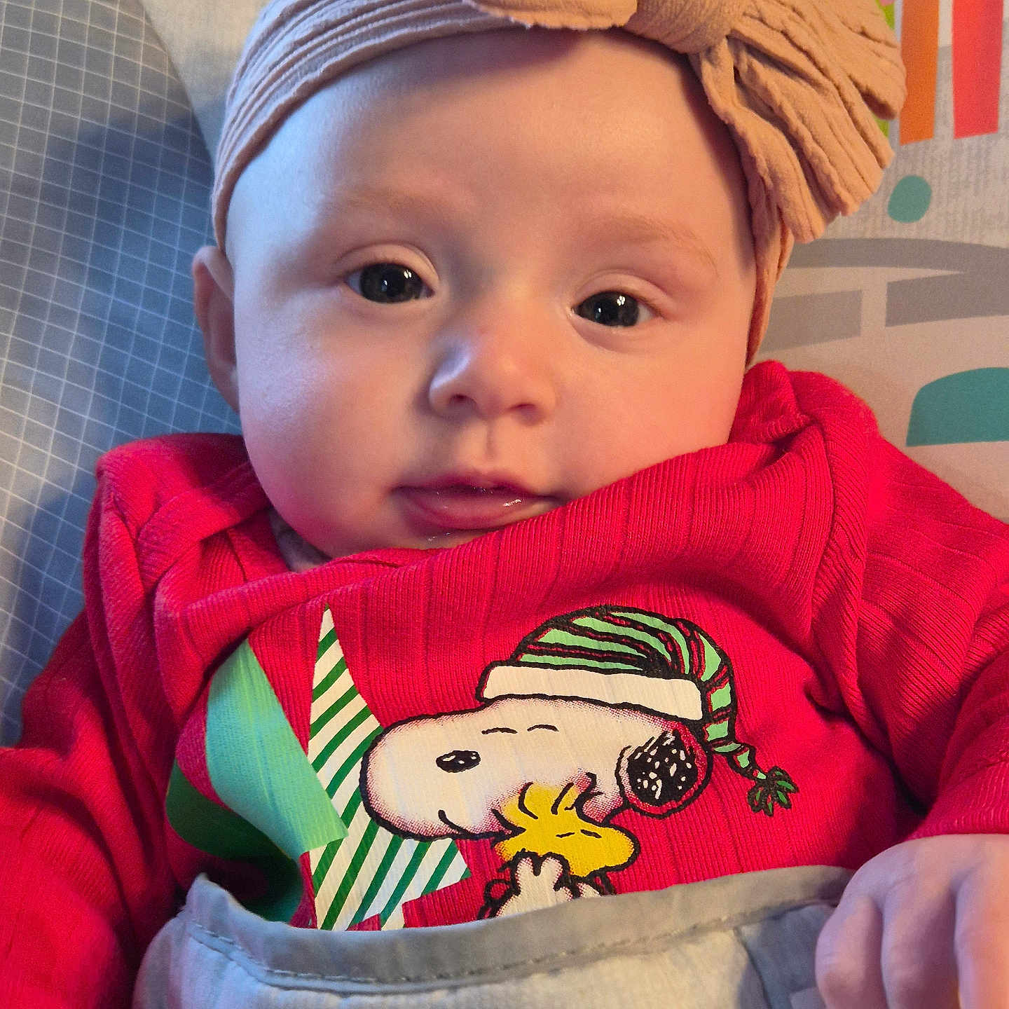 Fraeya is registered to the contest to win money with this photo: baby, blanket, bow, cartoon, child, closeup, clothing, cute, face, hand, headband, indoors, infant, monkey, pattern, portrait, red_sweater, smiling, snoopy, woodstock