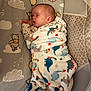 James is registered to the contest to win money with this photo: baby, sleeping, blanket, dinosaur_pattern, winnie_the_pooh, mattress, cozy, infant, bedtime, child, cute, soft, wrapped, indoors, peaceful, nursery, toddler, pajamas, face, resting