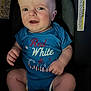 James joined the competition — help win amazing prizes! baby, infant, car_seat, onesie, blue_clothing, patriotic, face, hands, legs, sitting, child, warning_label, text_on_clothing, closeup, indoor, expression, cute, person, young_child, seat