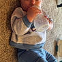 baby, blue_pants, bottle, carpet, child, cozy, cute, eyes, feeding, floor, gaze, hands, indoor, infant, lying_down, plastic_bottle, playtime, portrait, sweater, toddler