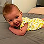 baby, infant, smile, bedroom, bed, blanket, clothing, yellow, white, lemon_print, cute, child, person, face, happy, skin, hair, toddler, resting, indoors