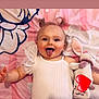 baby, bunny, child, cute, expression, face, happy, indoor, infant, lying_down, person, pigtails, pink_blanket, playful, smiling, soft_toy, stuffed_animal, tongue_out, toy, white_clothing