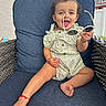 Sophia joined the competition — help win amazing prizes! toddler, child, baby, smiling, sunglasses, outdoor, patio, chair, cushion, portrait, sitting, dress, floral_pattern, barefoot, hair_bow, earrings, happy, sunny, wicker_furniture, house