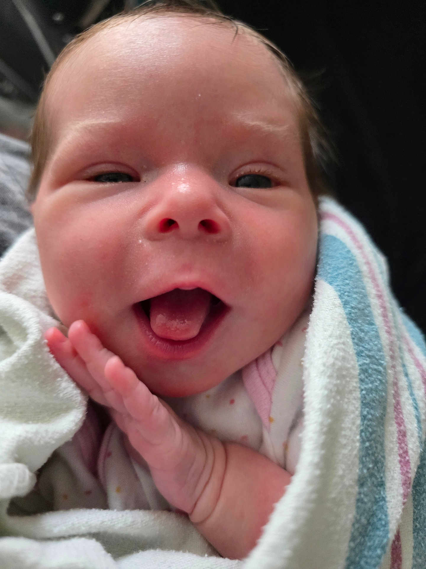Kayla is registered to the contest to win money with this photo: baby, infant, face, hand, tongue, blanket, wrapped, closeup, skin, newborn, cute, expression, happy, person, child, soft, texture, cozy, portrait, small