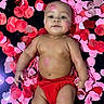 baby, infant, face, skin, red_clothing, diaper, lying_down, heart_petals, pink_petals, red_petals, love_theme, cute, portrait, baby_skin, child, adorable, baby_boy, baby_girl, happy, soft_lighting
