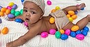 Amari is registered to the contest to win money with this photo: baby, child, colorful_eggs, curious, cute, easter, expression, grass, holiday, infant, knit_diaper_cover, knit_hat, laying_down, outdoor, plastic_eggs, playful, portrait, soft_texture, spring, white_blanket