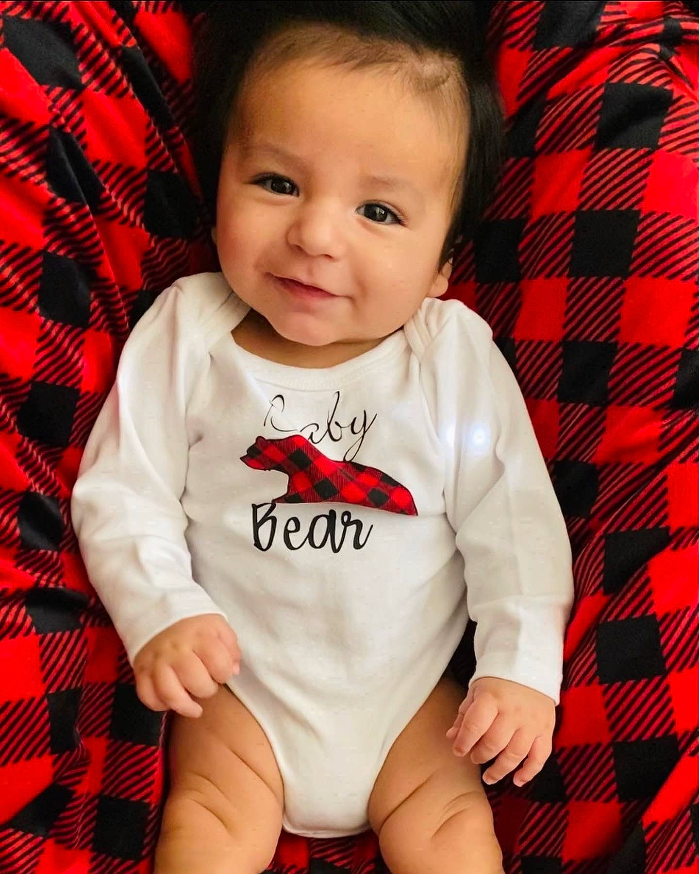 Isaac is registered to the contest to win money with this photo: baby, baby_toddler_clothing, cheek, child, cool, eye, face, happy, head, joy, pattern, person, plaid, red, skin, sleeve, smile, standing, t_shirt, tartan