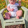 Riley joined the competition — help win amazing prizes! baby, child, outdoor, flower, orange_flower, green_chair, sunlight, nature, plant, grass, smiling, happy, summer, cute, one_person, sitting, daytime, infant, garden, playful