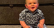 Riley is registered to the contest to win money with this photo: baby, child, infant, smiling, sitting, portrait, indoor, living_room, couch, carpet, plaid_shirt, pants, socks, rosy_cheeks, blond_hair, happy, family_photo, furniture, home, photography