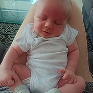 Louison participe au concours pour gagner de l'argent avec cette photo : baby, sleeping, infant, onesie, socks, person, legs, hand, home, carpet, couch, relaxation, comfort, child, peaceful, indoor, soft_light, skin, closeup, casual