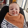 baby, bib, child, cozy, cute, face, furniture, hand, happy, home, indoor, infant, light, person, seated, skin, smiling, striped_shirt, window, wood