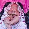 newborn, baby, infant, child, smiling, stroller, blanket, pink, outdoor, portrait, face, hands, feet, onesie, seated, lying_down, happy, cozy, floral_pattern, photography
