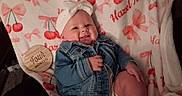 Hazel joined the competition — help win amazing prizes! baby, infant, child, smiling, portrait, denim_jacket, headband, blanket, cherry_pattern, bow_pattern, milestone_photo, four_months, wooden_sign, lying_down, indoor, cute, happy, face, hands, feet