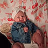 baby, infant, child, smiling, portrait, denim_jacket, headband, blanket, cherry_pattern, bow_pattern, milestone_photo, four_months, wooden_sign, lying_down, indoor, cute, happy, face, hands, feet