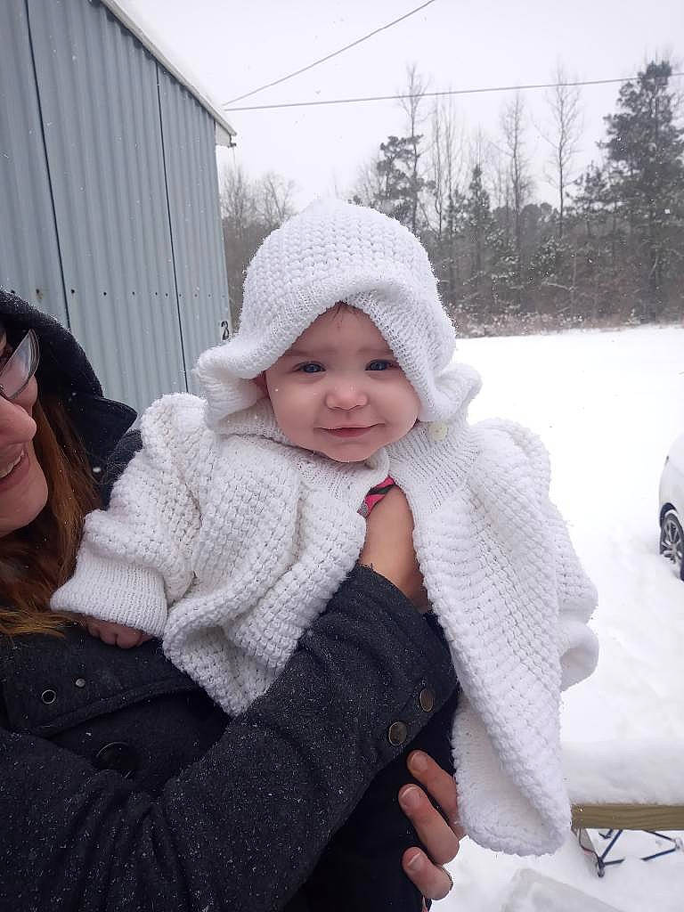 Lilyth is registered to the contest to win money with this photo: black, cap, child, event, eye, face, freezing, fun, fur, happy, headwear, human_body, jacket, joy, pattern, person, sky, smile, snow, toddler