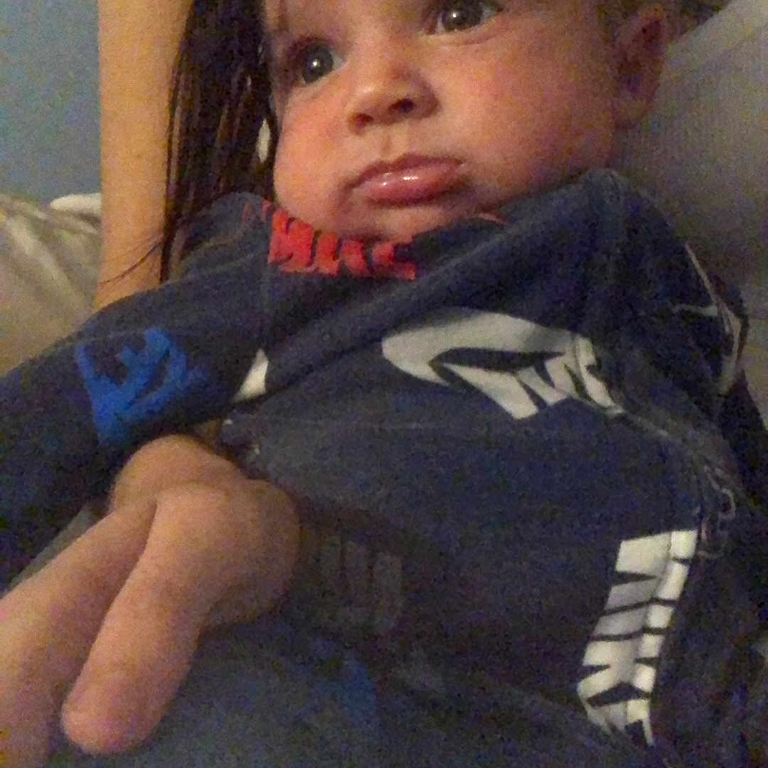 Demetrius is registered to the contest to win money with this photo: baby, blanket, bodypart, clothing, coat, face, finger, hand, head, hoodie, jacket, jeans, knitwear, pants, person, photography, portrait, sweater, sweatshirt, t_shirt