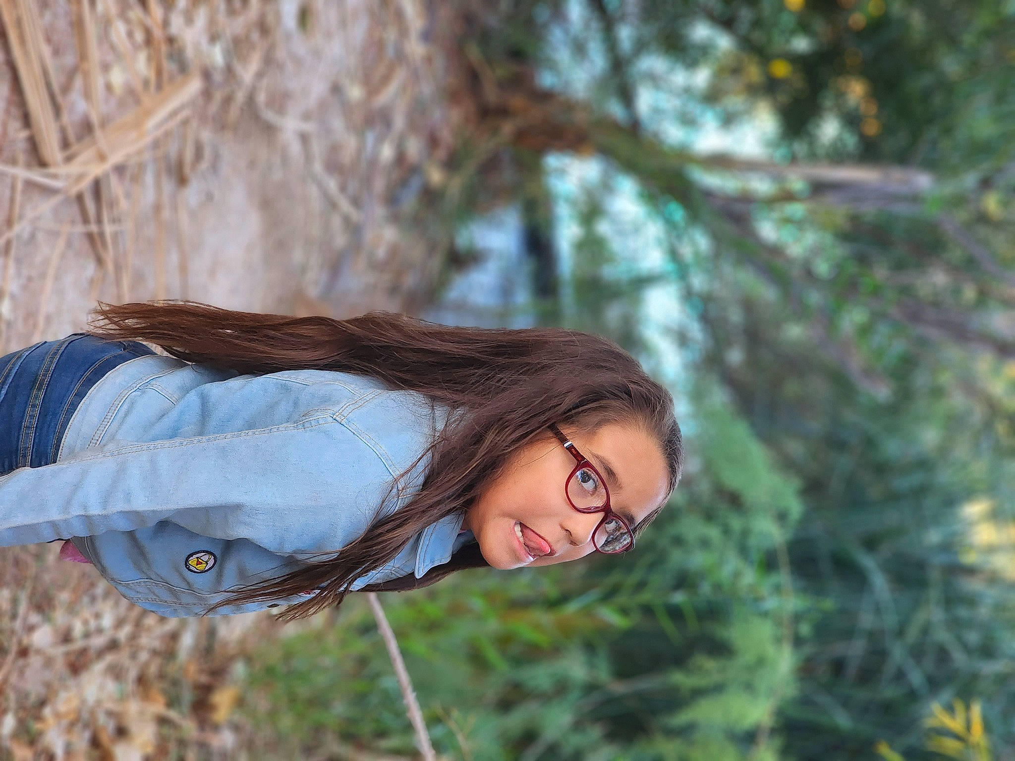 Lucy is registered to the contest to win money with this photo: black_hair, brown_hair, eye, eyewear, fawn, forest, fur, grass, happy, lip, long_hair, people_in_nature, person, plant, portrait_photography, sunglasses, tree, trunk, twig, wood