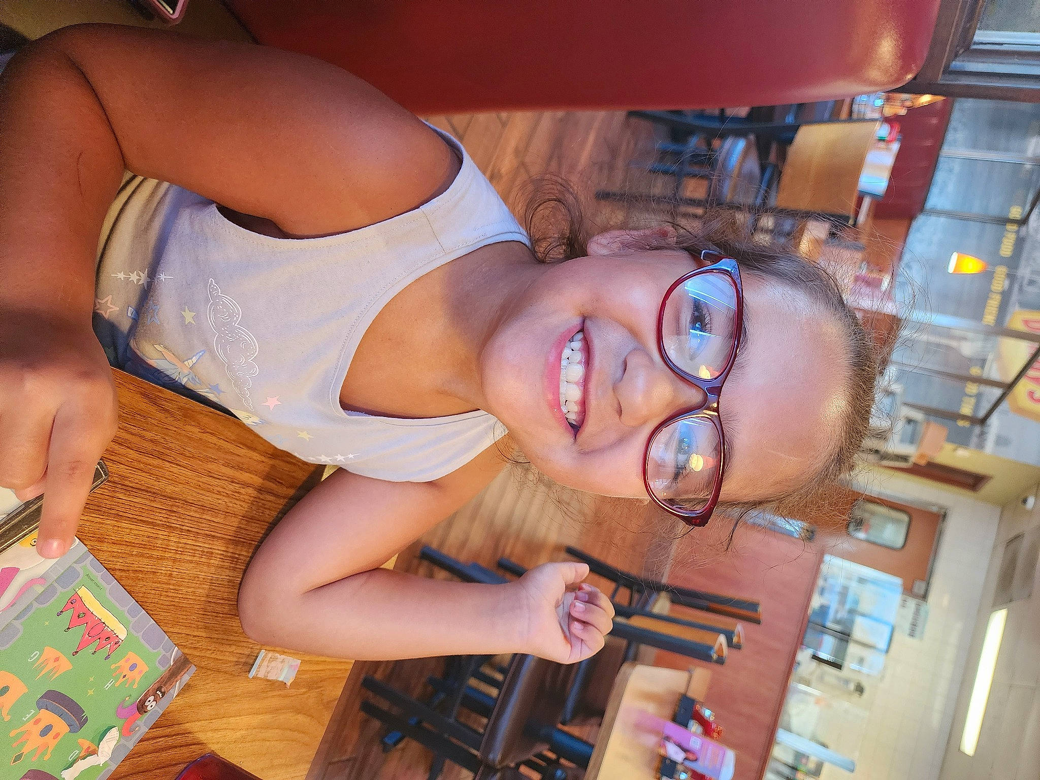 Lucy is registered to the contest to win money with this photo: abdomen, chest, elbow, eyewear, finger, fun, glasses, hand, happy, human_leg, joy, mouth, nail, person, room, smile, tableware, thigh, trunk, vision_care