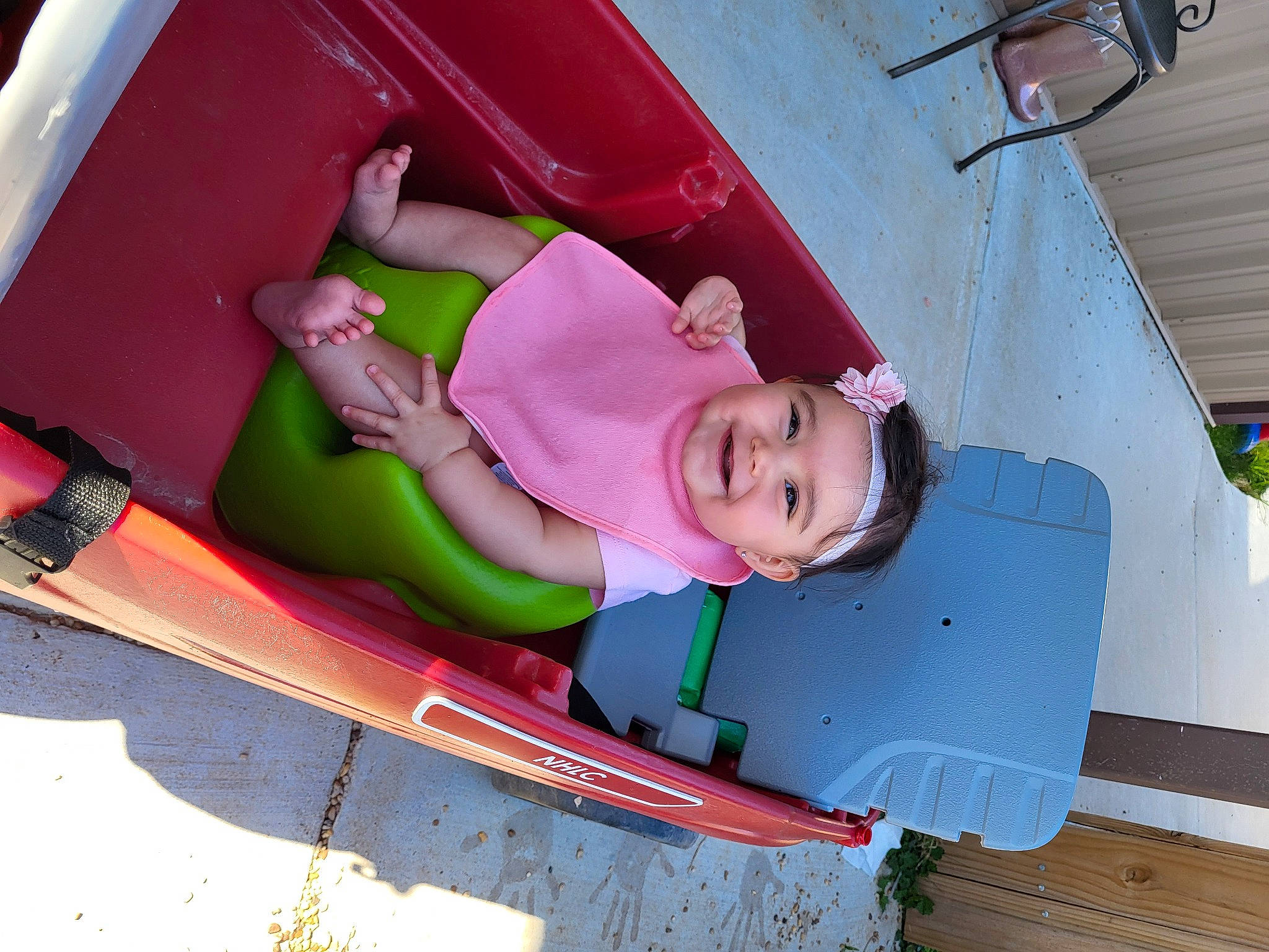 Emma is registered to the contest to win money with this photo: boats_and_boating_equipment_and_supplies, bumper, child, chute, fun, grass, headwear, joy, leisure, magenta, outdoor_play_equipment, person, pink, playground_slide, recreation, smile, sports_equipment, surfboard, surfing_equipment, toddler