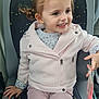 bus_seat, casual_clothing, child, cute, girl, handbag, happy, holding_object, indoor, jacket, light_pink, pants, patterned_seat, person, pigtails, portrait, seat, smiling, transport, young_child