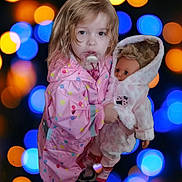 Laura participe au concours pour gagner de l'argent avec cette photo : child, toddler, raincoat, pink, polka_dot, doll, toy, pacifier, face, hair, bokeh, lights, blue, orange, clothing, footwear, indoor, portrait, cute, holding
