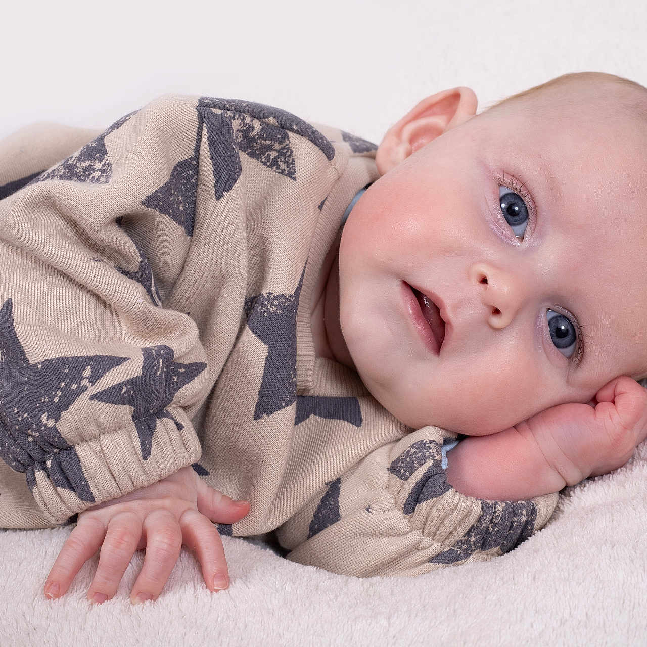 Nicolas participe au concours pour gagner de l'argent avec cette photo : baby, infant, blue_eyes, face, hand, clothing, star_pattern, blanket, soft_texture, lying_down, cute, portrait, child, skin, head, sleeve, newborn, pink_cheeks, resting, indoors