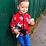 Lisandro a rejoint le concours — aidez-le/la à gagner de superbes lots ! child, boy, smiling, red_jacket, spiderman, plush_toy, snack, sidewalk, green_fence, blue_pants, sneakers, outdoor, standing, happy, casual_clothing, short_hair, daylight, urban, playful, cute