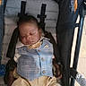 baby, sleeping, stroller, vest, pants, child, infant, seatbelt, comfort, peaceful, indoors, cute, portrait, young_child, resting, clothing, head, face, hands, footwear