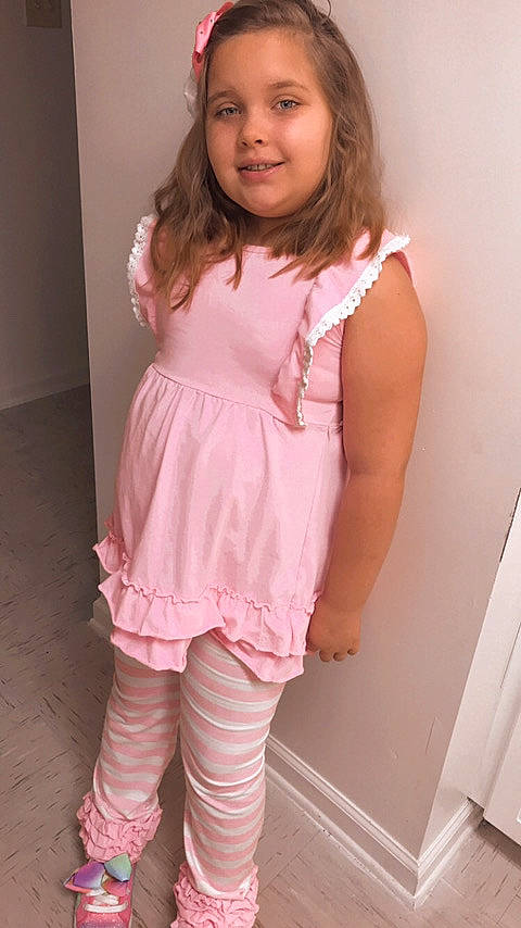 Skylit is registered to the contest to win money with this photo: baby_toddler_clothing, dress, elbow, face, fashion_design, hair, hand, head, joy, knee, leg, long_hair, magenta, neck, person, pink, skin, sleeve, smile, thigh