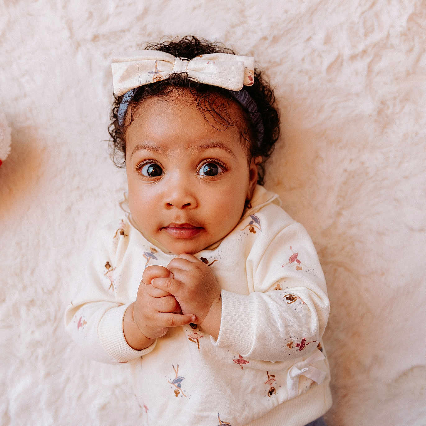 Lucinda joined the competition — help win amazing prizes! baby, ballerina_print, big_eyes, blanket, bow, child, cozy, curly_hair, cute, hands_clasped, headband, indoors, infant, lying_down, plush_toy, portrait, red_and_white, soft_texture, sweater, warm